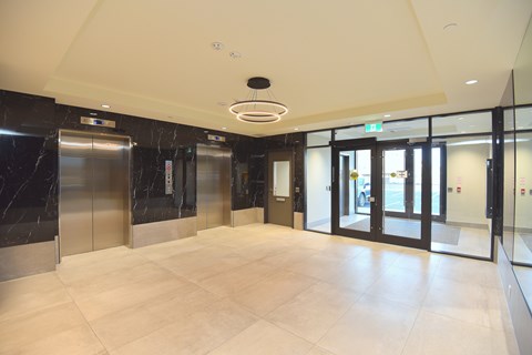 A spacious lobby with marble floors and a ceiling light at Roxy Apartments, Ontario, L8H 0B7