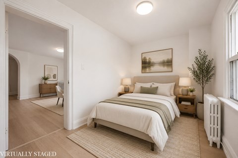A bedroom with a large bed and a painting on the wall.