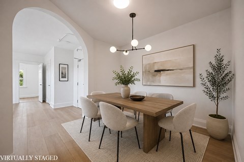 A dining room with a wooden table and chairs.