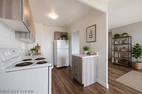 A kitchen with a white stove top oven and a white refrigerator.