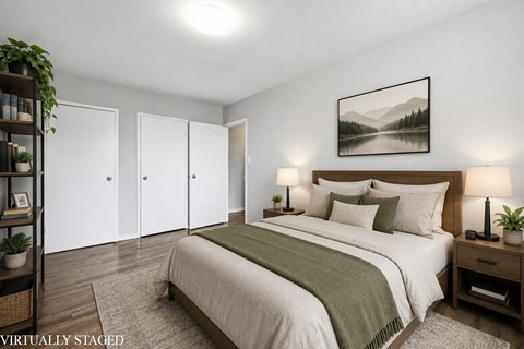 A bedroom with a bed, nightstand, and a painting on the wall.