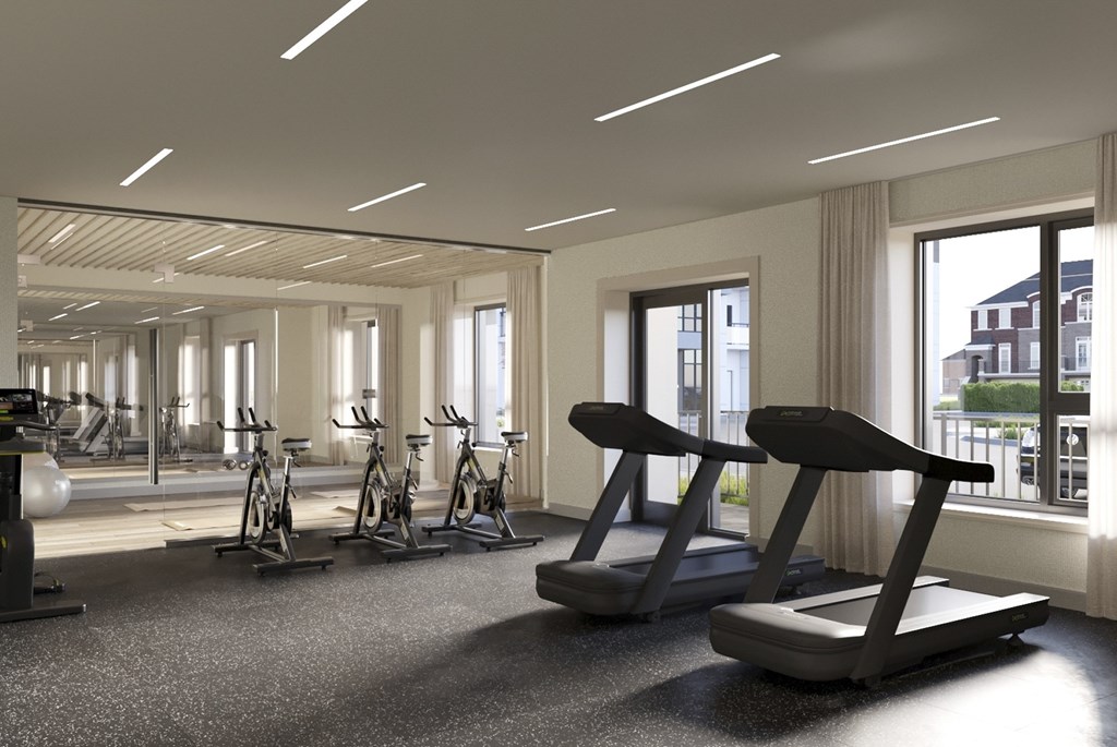 A spacious gym with treadmills, exercise bikes, and a view of the city. A spacious gym with treadmills, exercise bikes, and a view of the city at Roxy Apartments, Hamilton, ON