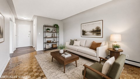 A living room with a white couch, a coffee table, and a lamp.