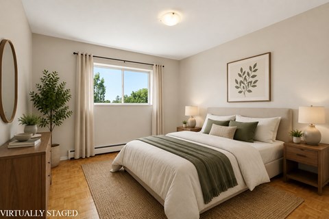 A bedroom with a large bed and a window with curtains.