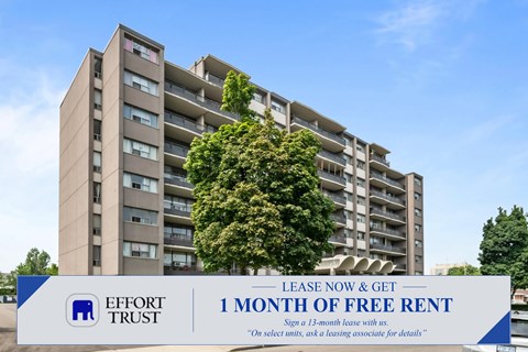 A tall building with a tree in front of it and a sign that says "1 MONTH OF FREE RENT".