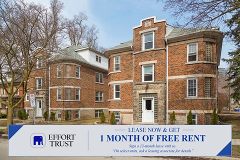 A large brick building with a sign offering a free month of rent.