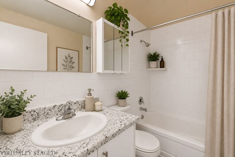 A bathroom with a white sink and a white toilet.