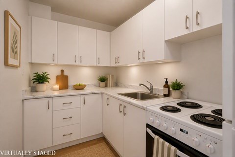 A white kitchen with a stove and sink.
