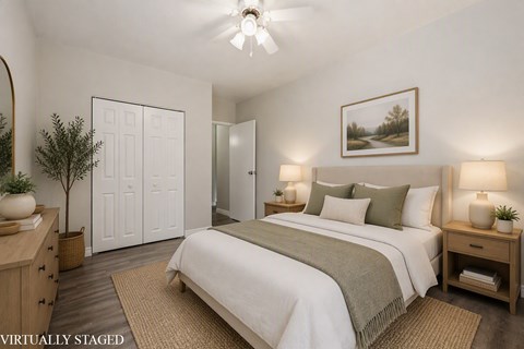 A bedroom with a bed, nightstands, and a painting on the wall.
