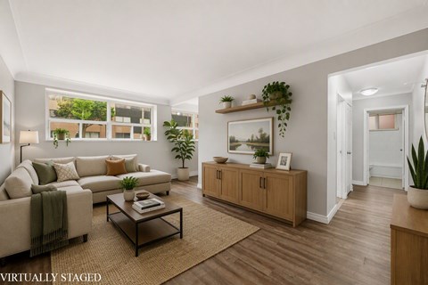 A living room with a couch, a coffee table, and a large window.