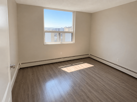 Empty room with a window overlooking the city.