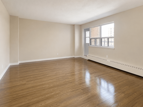Empty room with wooden floors and a window.