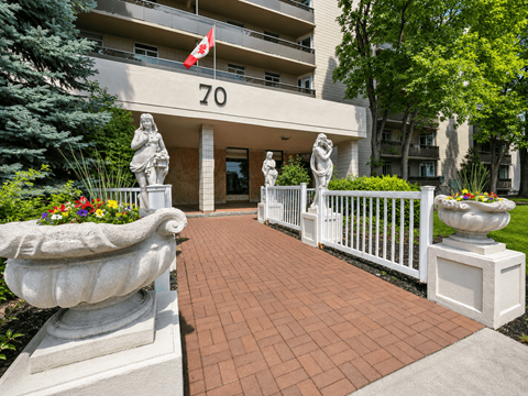 A building with the number 70 on it is surrounded by statues and trees.