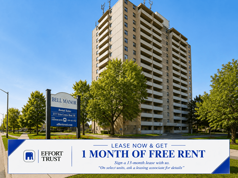 A tall building with a sign in front that says "Bell Manor" and "1 month of free rent".