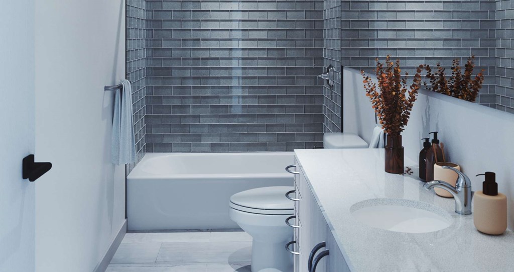 A white bathroom with a tub, toilet, and sink.at Ophelia on Queen, Kitchener, N2G 0E7