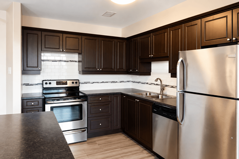 A kitchen with dark brown cabinets and stainless steel appliances.