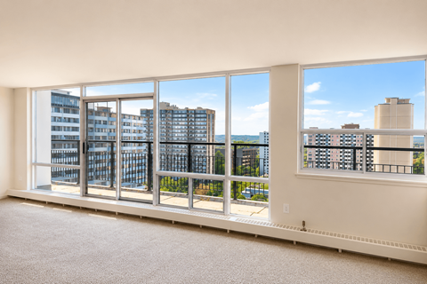 A room with a large window overlooking a cityscape.