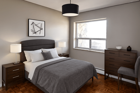 A bedroom with a large bed, a nightstand, and a chair.