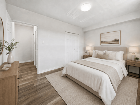 A bedroom with a large bed and a wooden dresser.