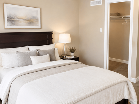 A bedroom with a large bed and a painting on the wall.