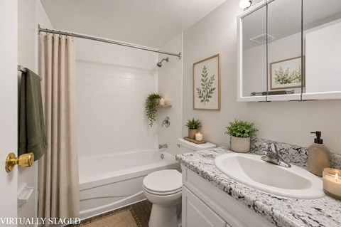 A bathroom with a marble countertop and a white toilet.