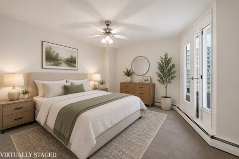A bedroom with a bed, nightstands, and a ceiling fan.