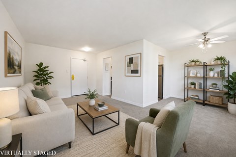 A living room with a grey couch, a green armchair, and a coffee table.