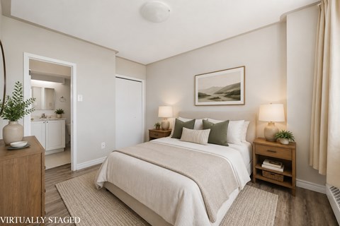 A bedroom with a large bed and a painting on the wall.