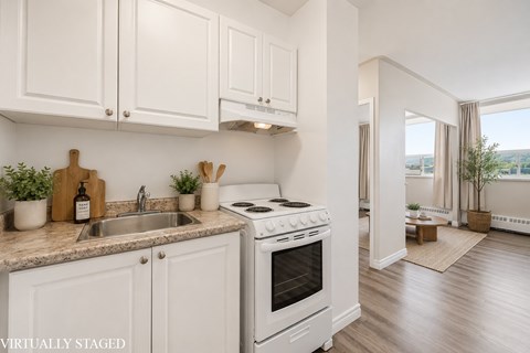 A kitchen with white cabinets and a stove top oven.