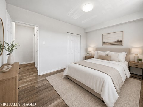 A bedroom with a large bed and a wooden dresser.