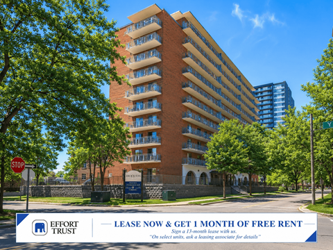 A large brick building with a sign offering a free month of rent for a 13-month lease.