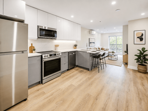 A modern kitchen with wooden floors and stainless steel appliances.
