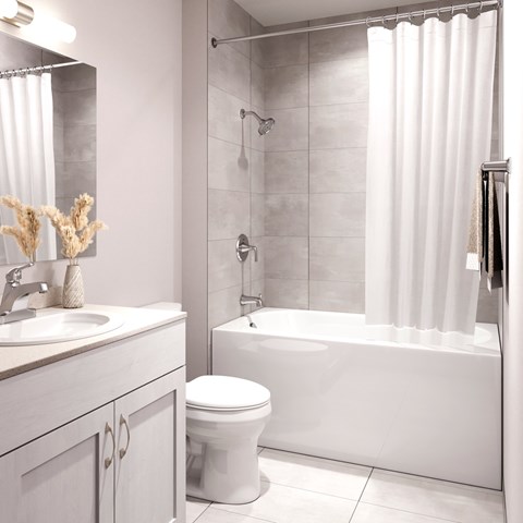 A white bathroom with a toilet, sink, and bathtub.at The Maverick, Kitchener, N2H 0E3