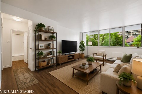 A living room with a couch, a coffee table, and a television.