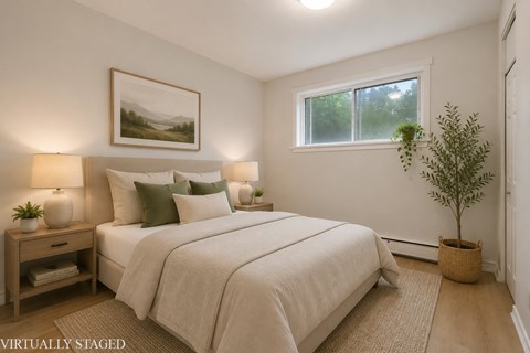 A bedroom with a large bed and a painting on the wall.