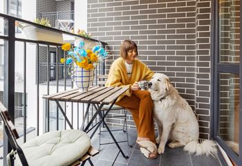 A woman in a yellow sweater is sitting at a table with a white dog.at The Maverick, Kitchener, ON