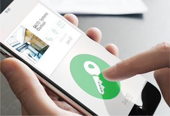 A hand is holding a smartphone with a key icon on the screen.at The Maverick, Kitchener, ON N2H 0E3