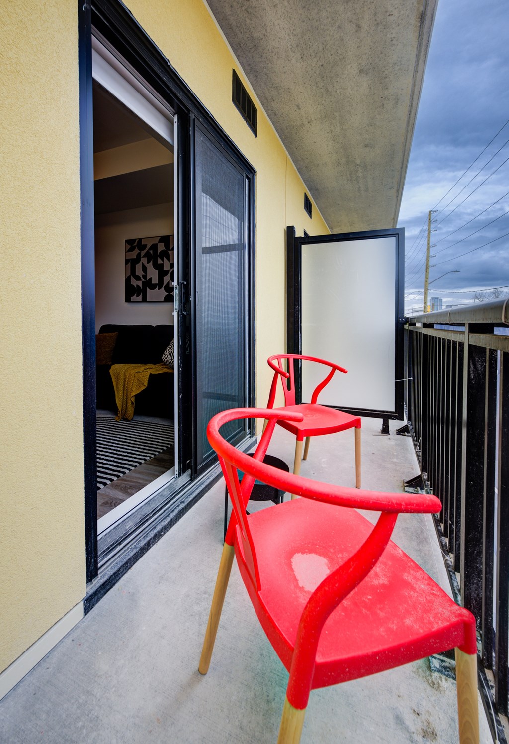 A red chair sits on a balcony.