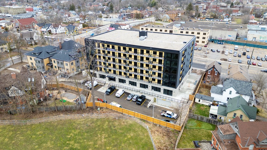 A large building with a lot of windows is surrounded by a parking lot.