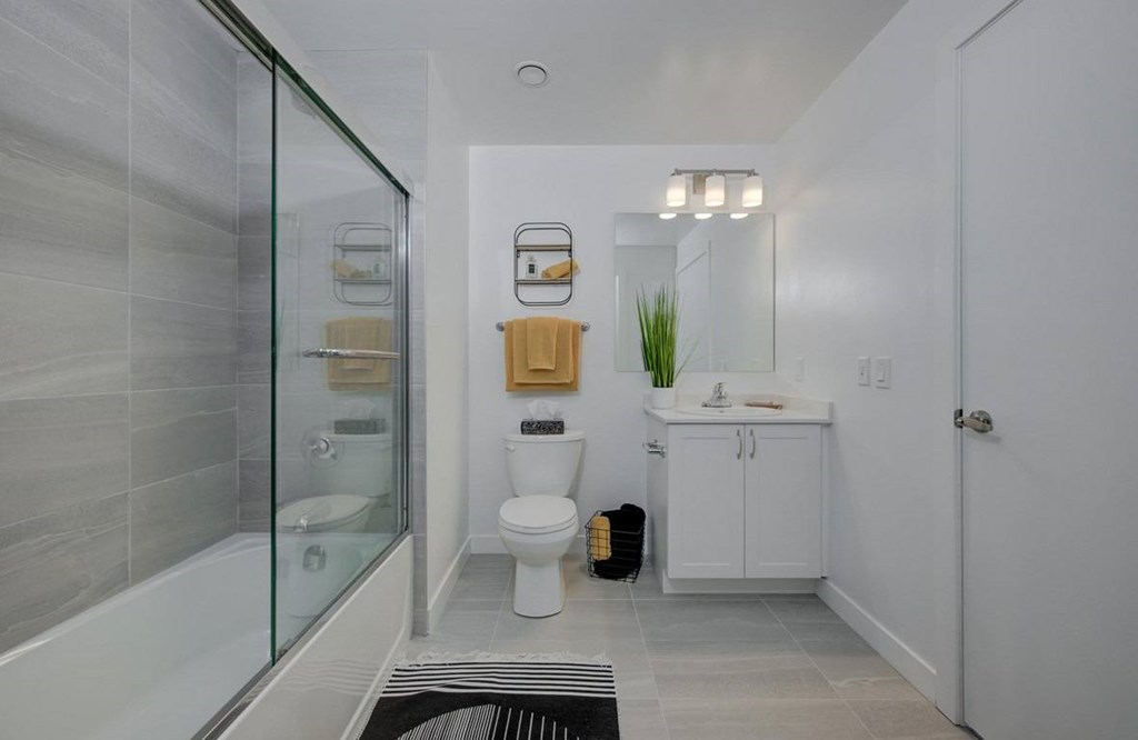A bathroom with a glass shower enclosure and a white toilet.at The Maverick, Kitchener
