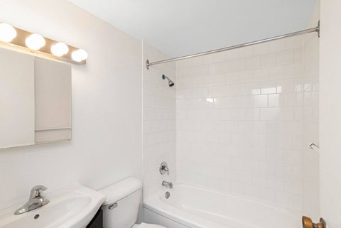 A white bathroom with a sink, toilet, and bathtub.