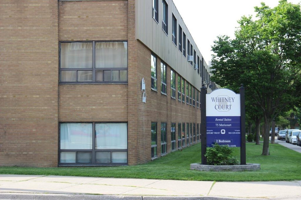 A sign in front of a building that says Whitemey Court.