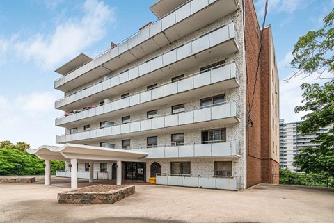 A large white building with a red brick base and a white canopy.