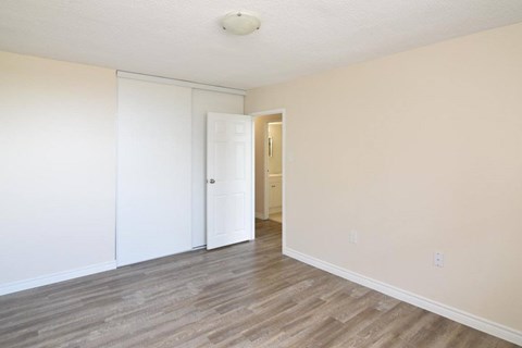 A room with a white door and a light brown floor.