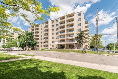 A large apartment building with a grassy area in front.