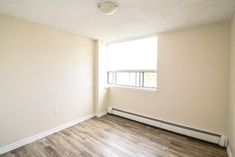 A room with a window and a radiator on the wall.
