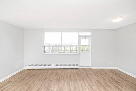 A room with a white door and a window with blinds.