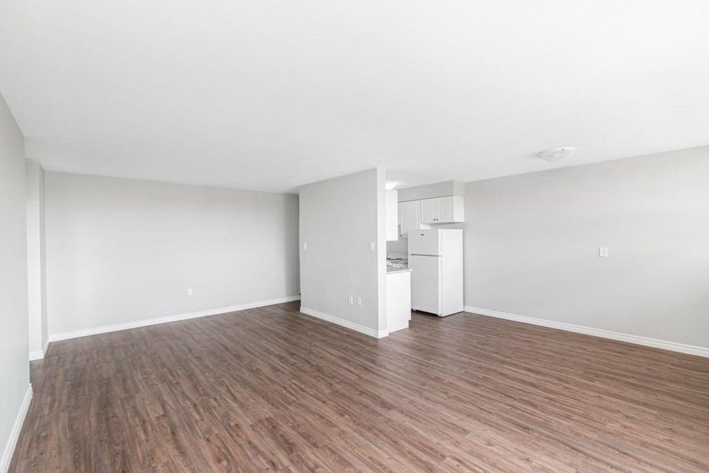A room with wooden flooring and white walls.