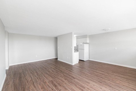 A room with wooden flooring and white walls.