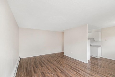 A room with wooden flooring and white walls.